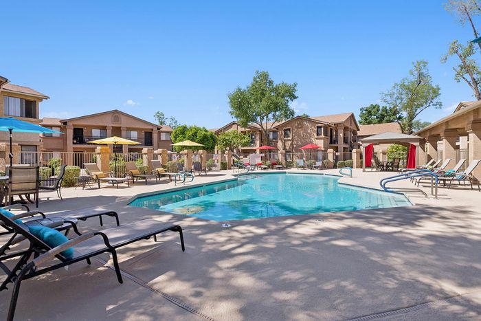 Pool at Orchard Mesa with pool chairs and umbrellas