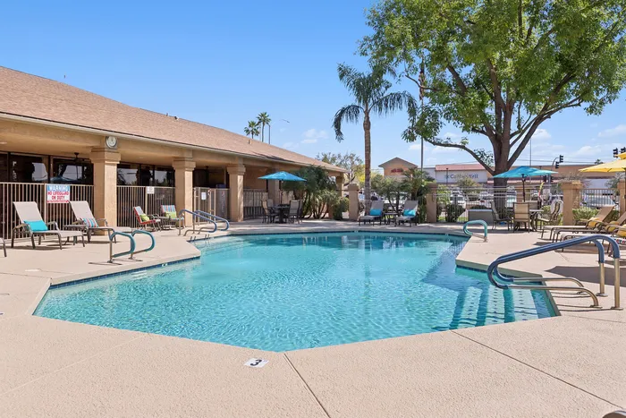 Pool at Orchard Mesa with pool chairs and umbrellas