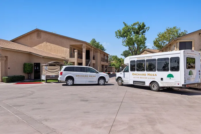 Orchard mesa bus and ADA van with Orchard Mesa branding