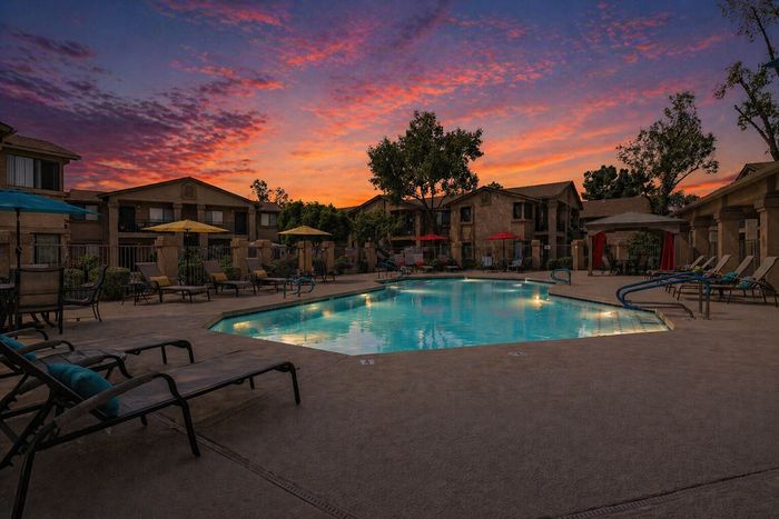 The pool at orchard mesa at sunset with seating and umbrellas