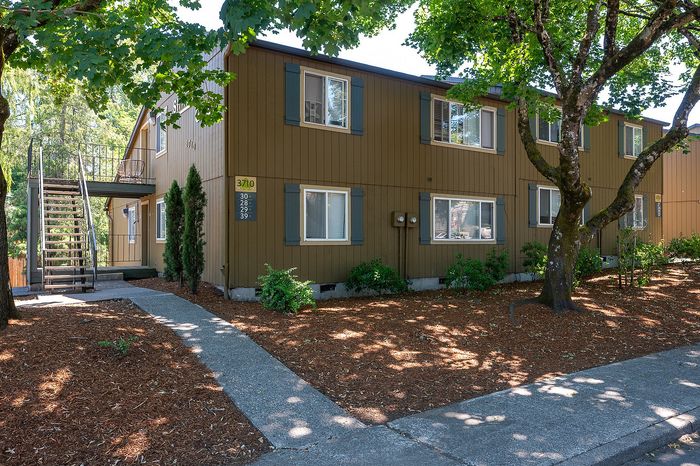 Shady Glen Exterior with trees, brown paint and blue shutters