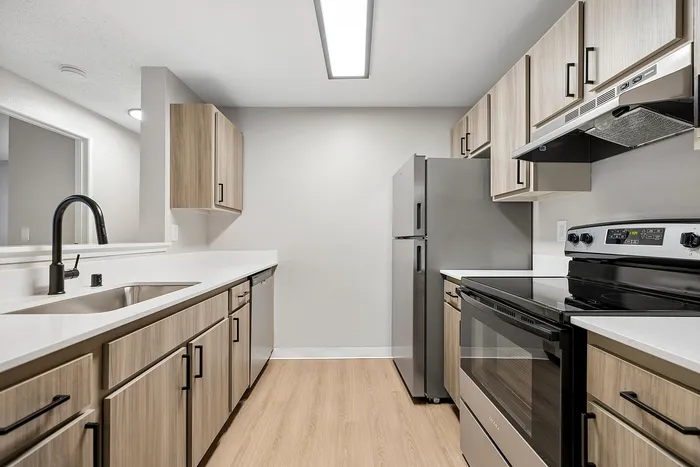 Kitchen at Timber Flats with wood cabinets, black hardware and wood floors
