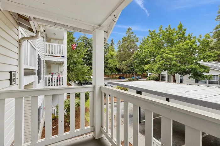 Patio of unit J201 with ciew above carport and trees