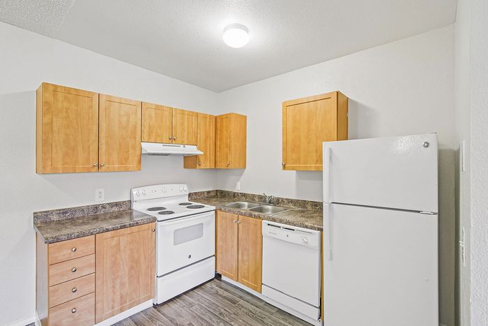 kitchen in the 1x1 floorplan at ventura villas with white appliances and woord cabinets