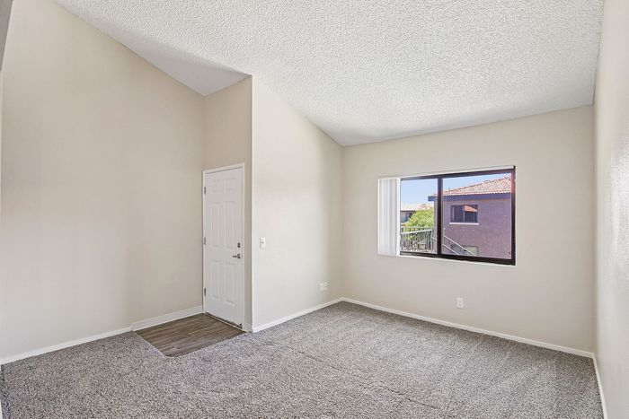 living room at ventura villas 1x1 with carpet and a window and entry door