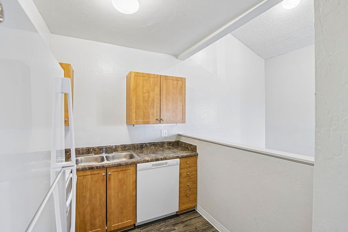 kitchen at ventura villas with brown cabinets and white appliances