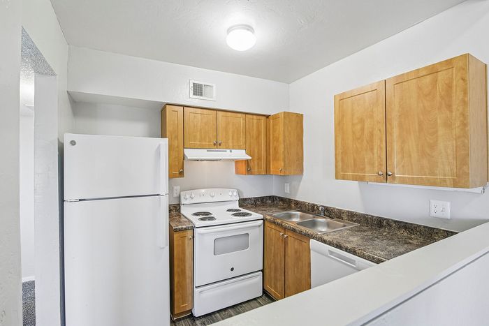 kitchen in 2xa floorplan at ventura villas with wood cabinets and white appliances
