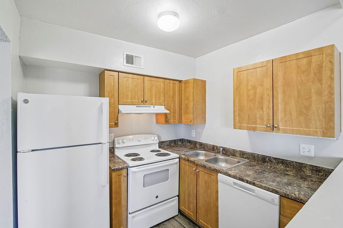 kitchen in 2xa floorplan at ventura villas with wood cabinets and white appliances