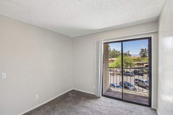 primary bedroom at ventura villas with sliding glass doors and a patio  and carpet
