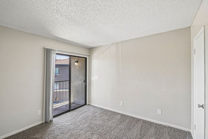 primary bedroom at ventura villas with sliding glass doors and a patio and carpet