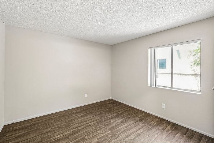 Spacious Deer Valley Village bedroom featuring vinyl plank flooring and a large window.