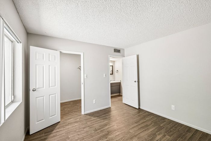Deer Valley Village bedroom with wood-style flooring and doors leading to a closet and bathroom.