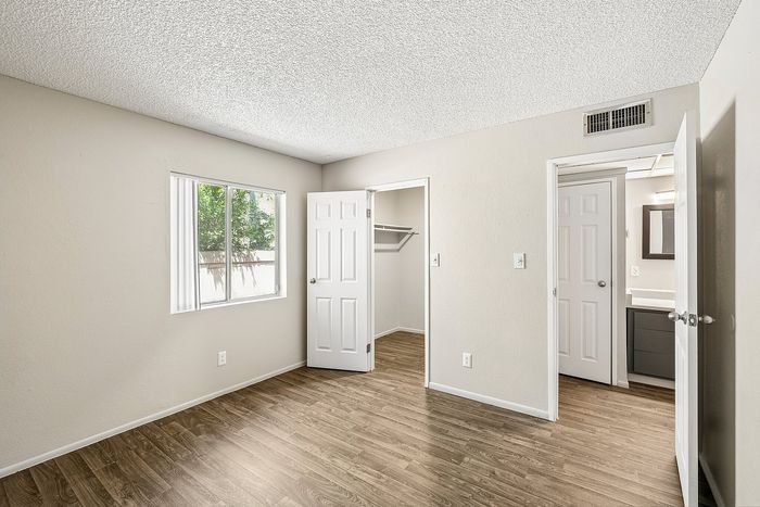 Bright Deer Valley Village bedroom with vinyl flooring and views of the closet and bathroom.