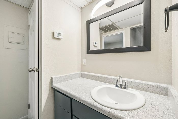 Detail of white bathroom sink and grey vanity with framed mirror at Deer Valley Village.