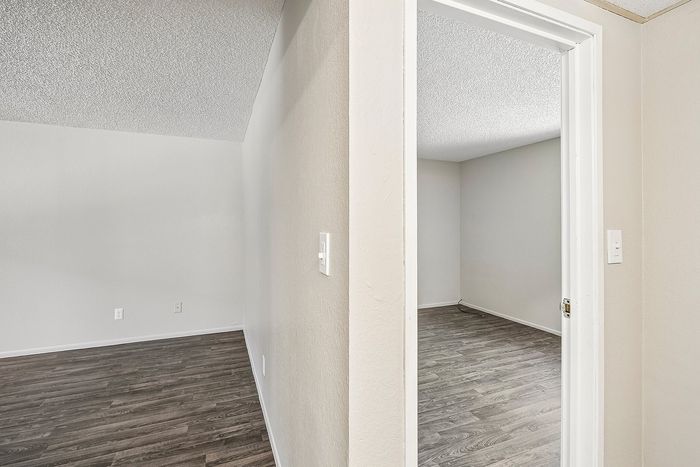 Hallway view at Deer Valley Village showing wood-style vinyl flooring and neutral interior paint.
