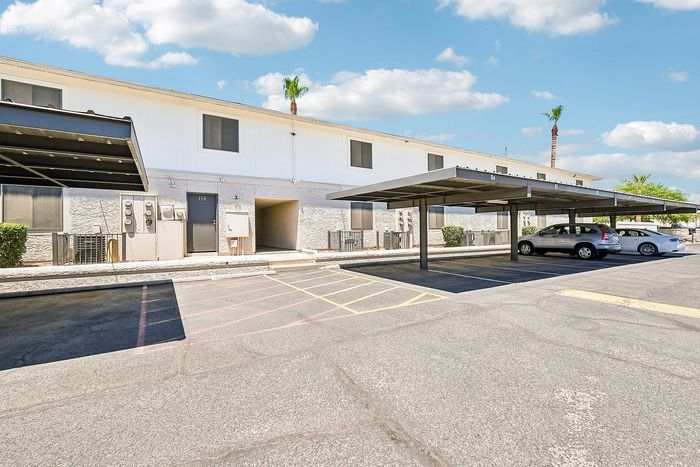 Deer Valley Village exterior building with covered parking stalls and desert landscaping.