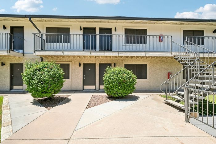 Deer Valley Village building exterior with dark entry doors and landscaped green bushes.