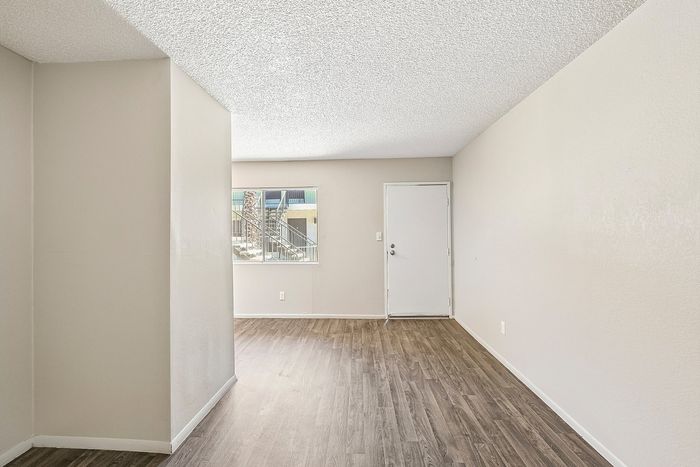 Deer Valley Village living room with vinyl plank flooring and a white front entry door.