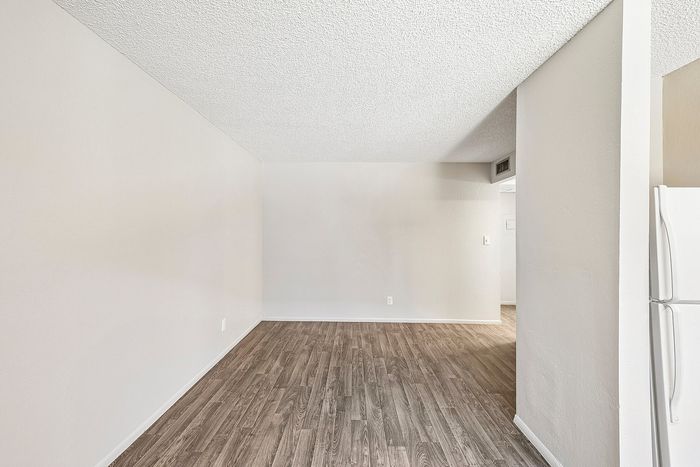 Empty Deer Valley Village living area featuring wood-style vinyl plank flooring and neutral walls.