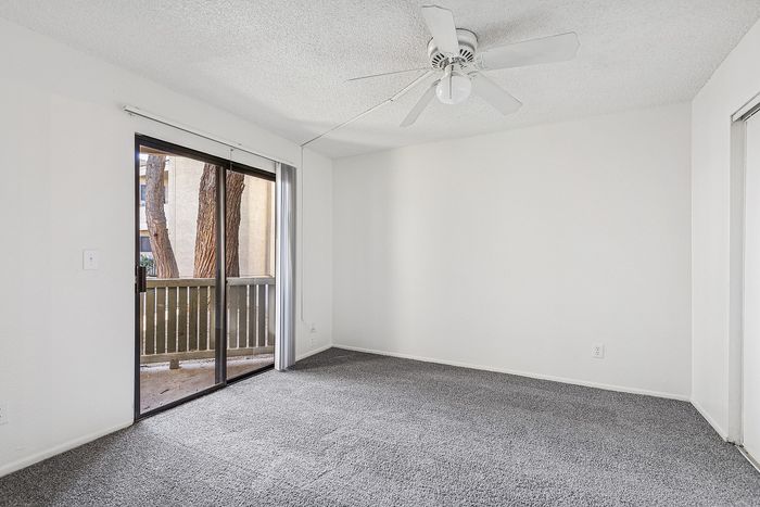 Bedroom at Silver Creek with carpet and ceiling fan with sliding glass door to the patio