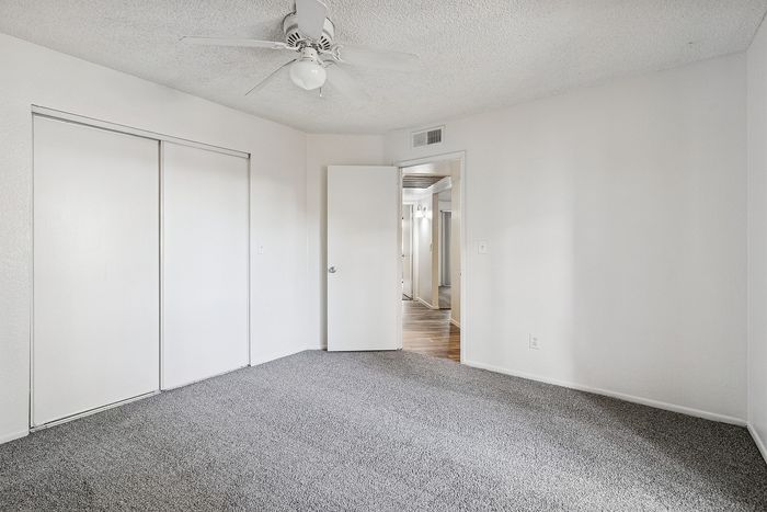 Bedroom with closet and ceiling fan and carpet