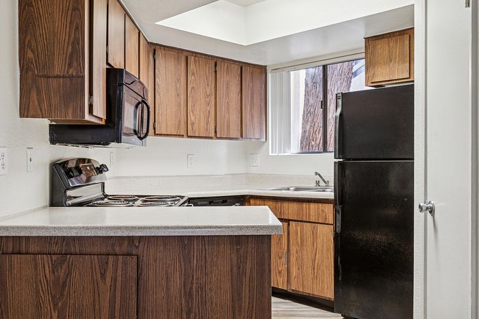 Kitchen at Silver Creek with black appliances and wood cabinets