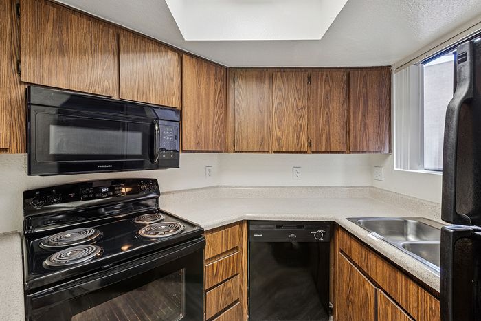 Kitchen at Silver Creek with black appliances and wood cabinets