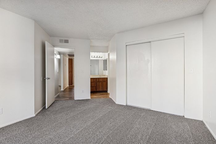 Bedroom at Silver Creek with carpet and a closet and an attached bathroom