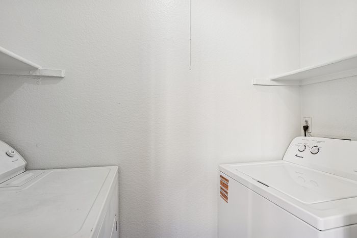 Laundry room with white appliances