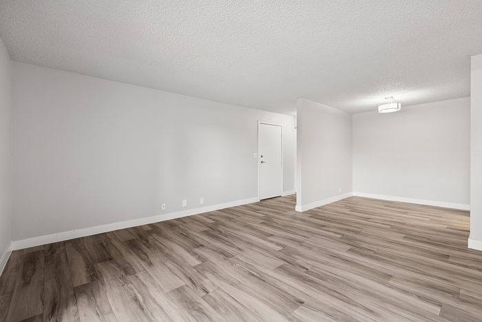 Living room of a unit at Peoria Grand with wood floors and a dining nook