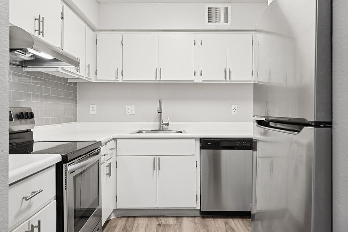 Kitchen at Peoria Grand with stainless steel appliances and all white cabinets
