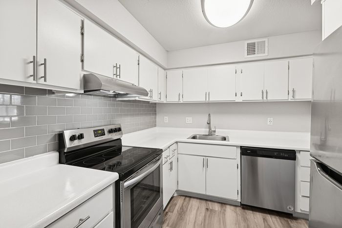 Kitchen at Peoria Grand with stainless steel appliances and all white cabinets