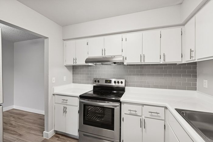 Kitchen at Peoria Grand with stainless steel appliances and all white cabinets