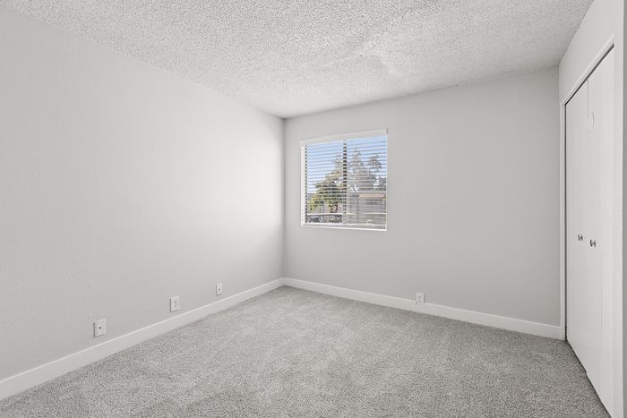 Bedroom at Peoria grand with closet and window, light grey carpet and light grey walls