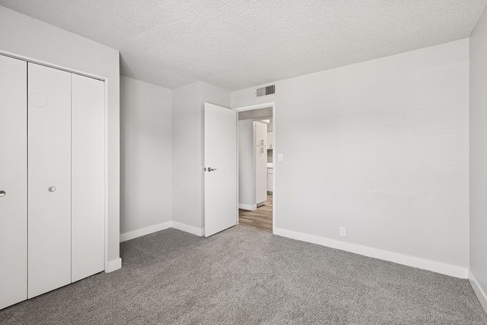 Bedroom at Peoria grand with closet and window, light grey carpet and light grey walls