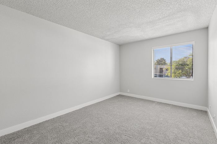 Bedroom at Peoria grand with closet and window, light grey carpet and light grey walls
