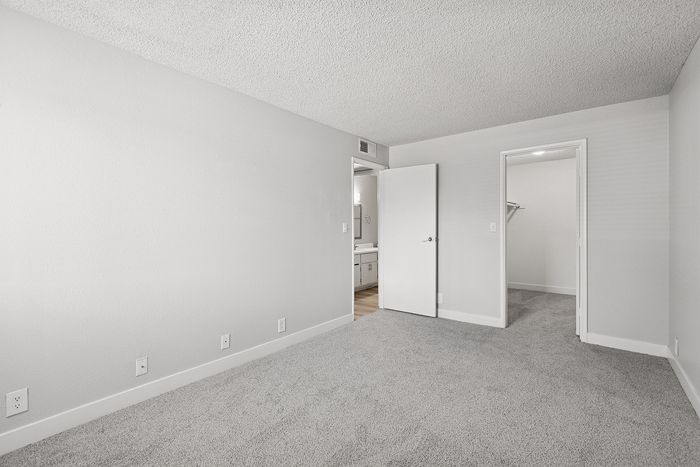 Bedroom at Peoria grand with closet and window, light grey carpet and light grey walls