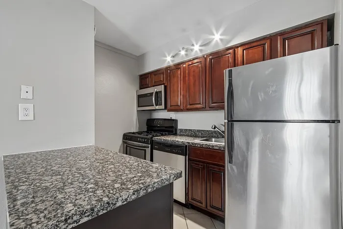 Kitchen at Solaris at the biltmore with stainless appliances and dark wood cabinets