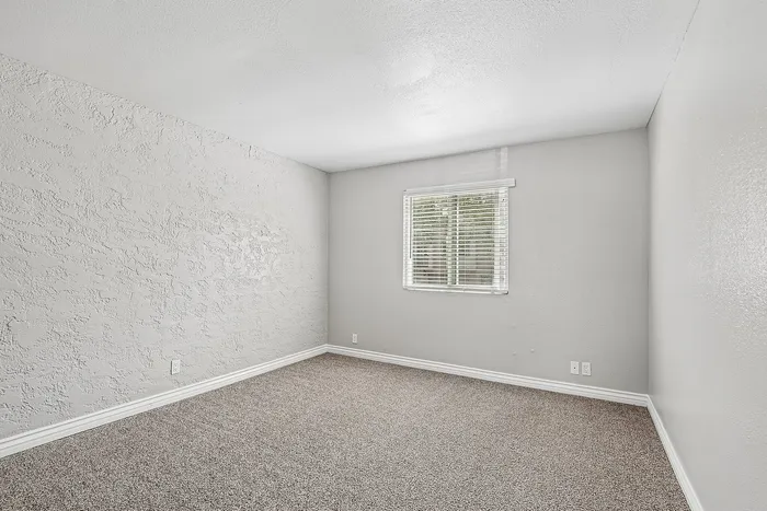 bedroom at Solaris at the biltmore with carpet and grey paint and a window