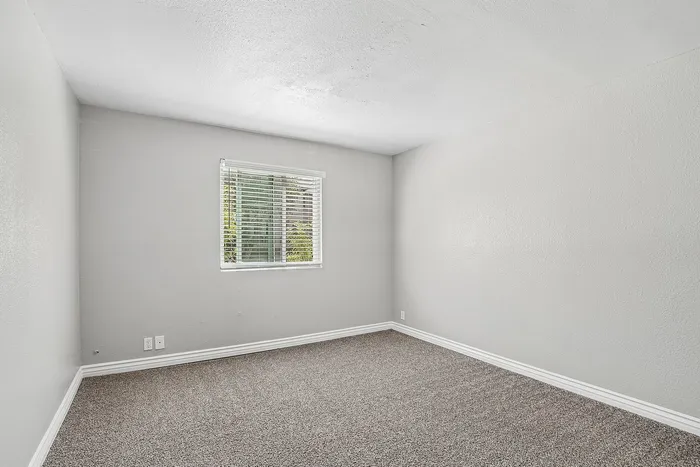 bedroom at Solaris at the biltmore with carpet and grey paint and a window