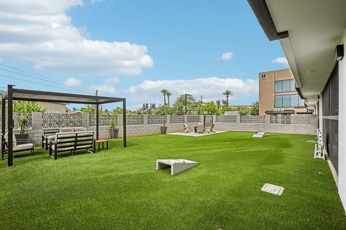 outdoor courtyard with cornhole and a community firepit