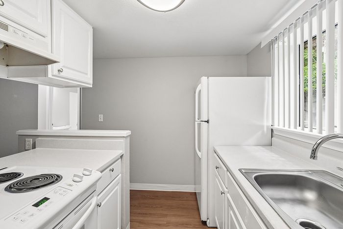 Kitchen at Creekwood with all white appliances and a window over the sink