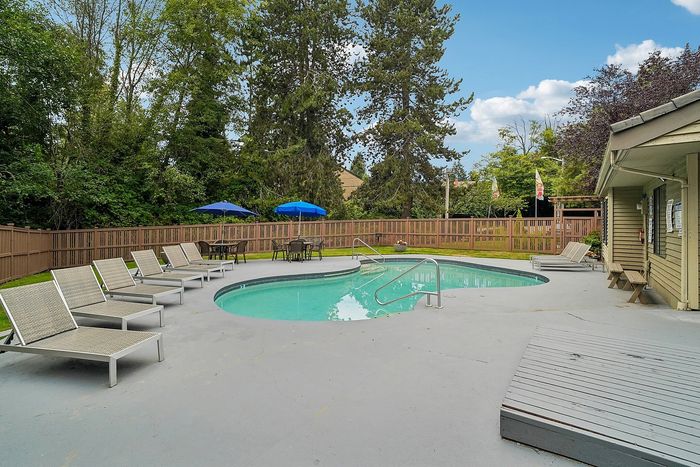 Pool at Creekwood with lounge chairs and tables and chairs