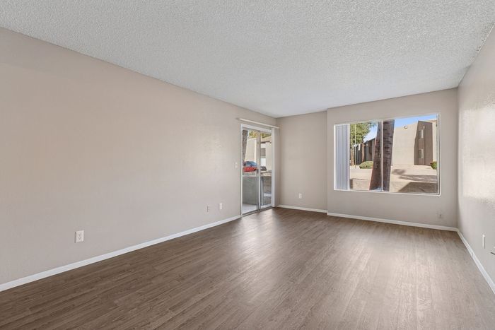 Solaris at Shadow Mountain living room with vinyl plank flooring and sliding glass door to a patio.