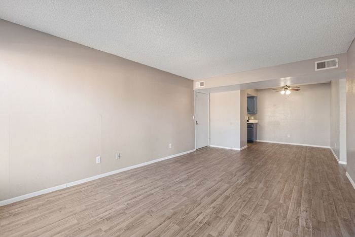 Spacious living and dining area at Solaris at Shadow Mountain with modern wood-style flooring.