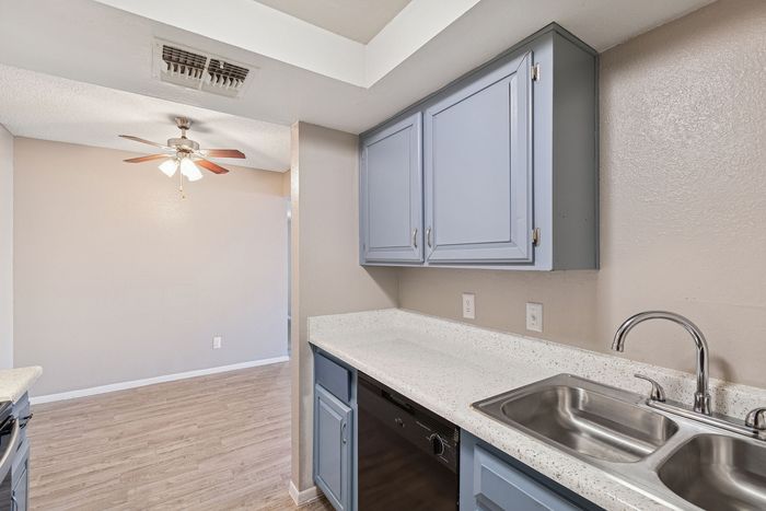 Kitchen at Solaris at Shadow Mountain with blue cabinetry and white countertops overlooking the dining area.