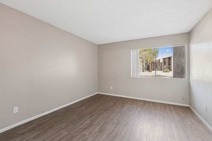 Bedroom at Solaris at Shadow Mountain featuring vinyl plank flooring and a large window.