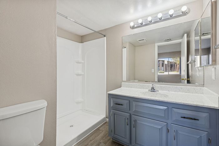 Bathroom at Solaris at Shadow Mountain with a blue vanity, white counter, and walk-in shower.
