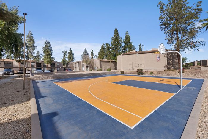 Full-view of the outdoor basketball court with a mountain backdrop.