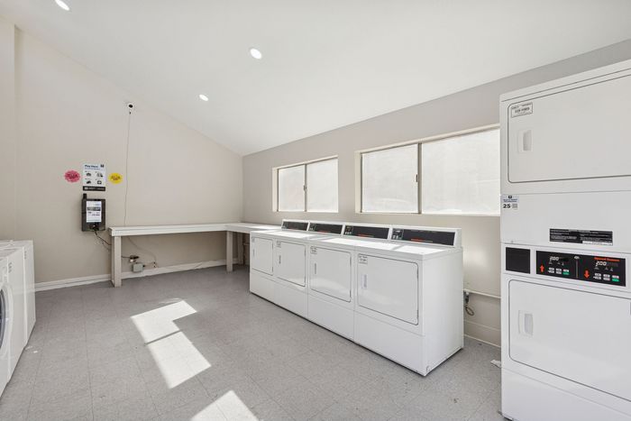Row of white commercial dryers inside the laundry care center at Solaris at Shadow Mountain.